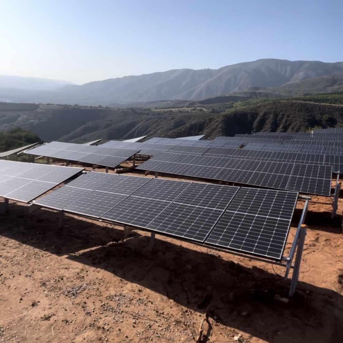 Rows of ground-mounted solar panels on a hillside