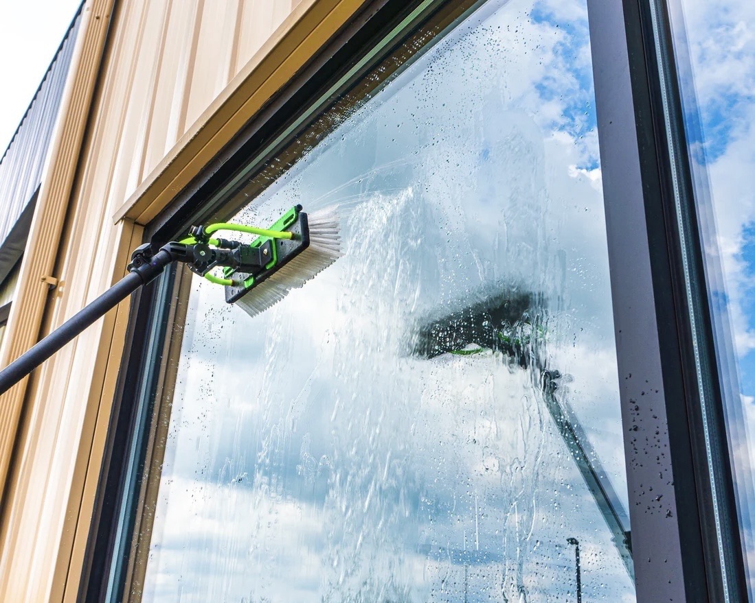 Water-fed pole brush cleaning an exterior window